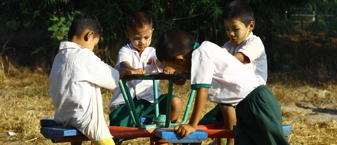 回転遊具で遊ぶ移民学校の子ども達